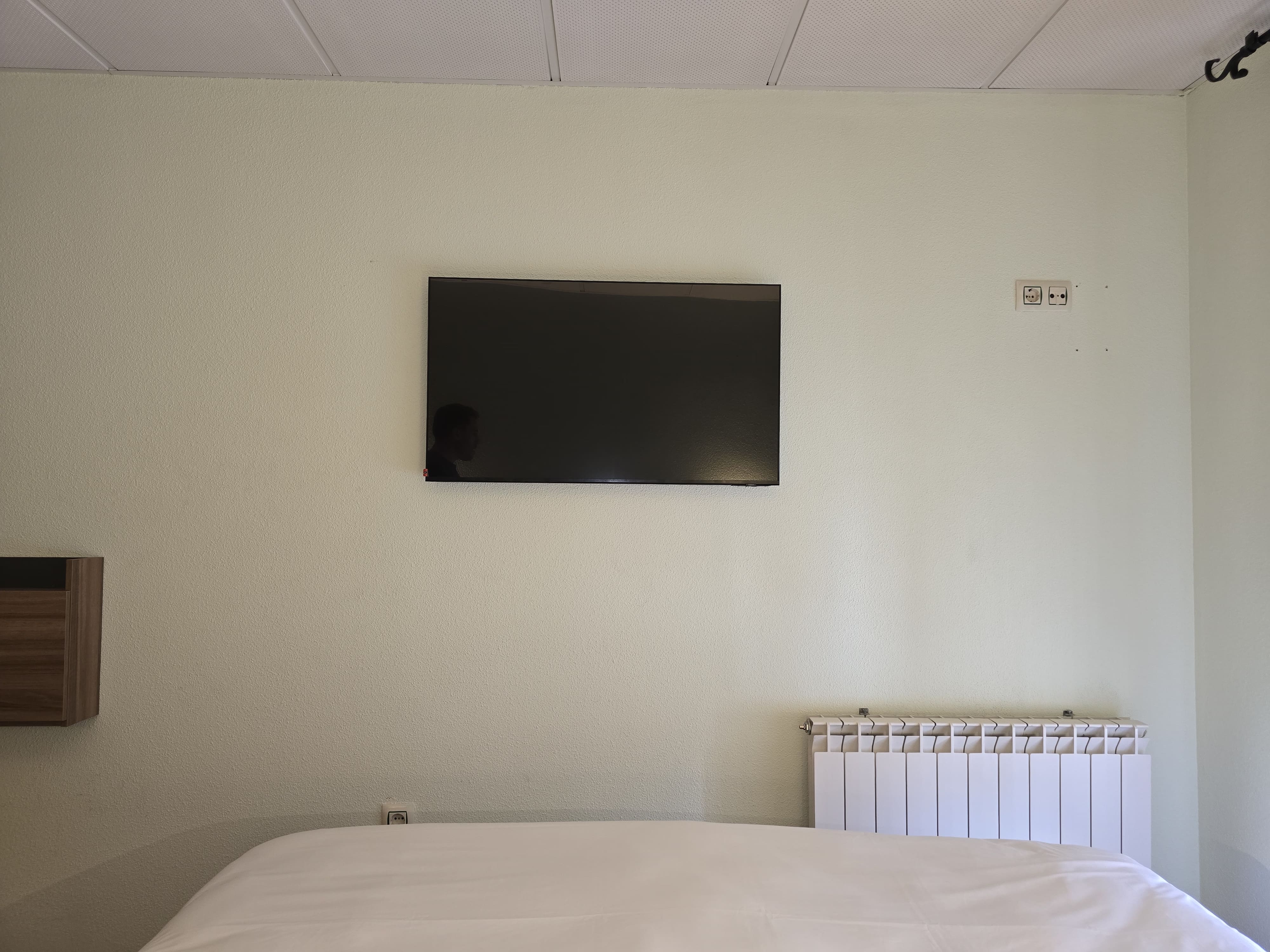 Cama matrimonial en habitación doble Hostal La Cigüeña El Espinar